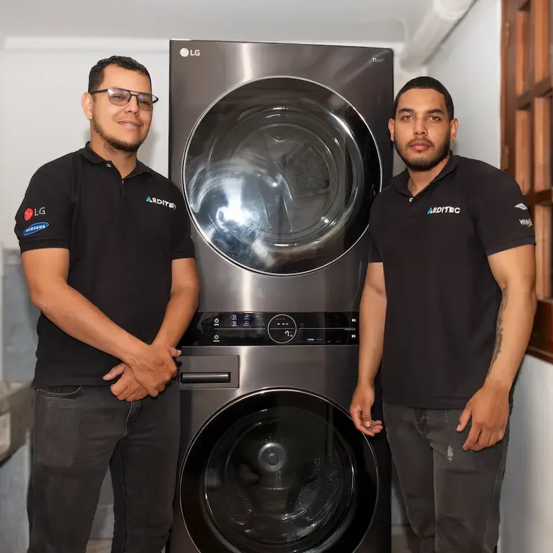 hombres de arditec parados al lado de una lavadora